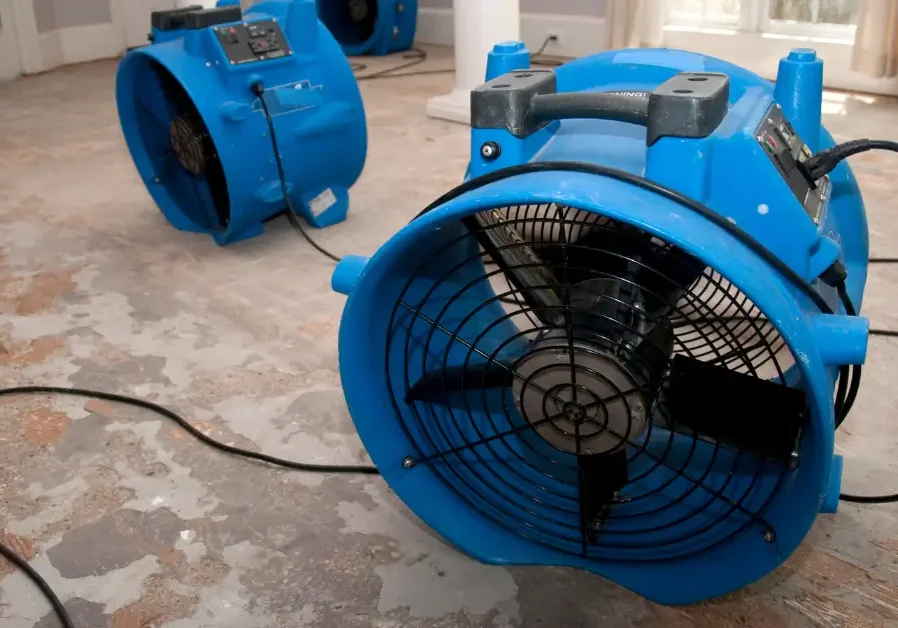 Blue industrial fans drying wet floor
