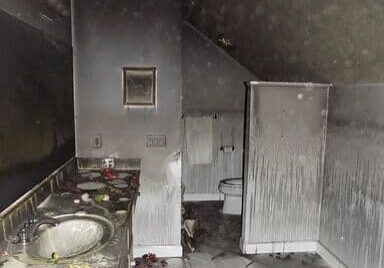 Burnt bathroom with smoke-stained walls.