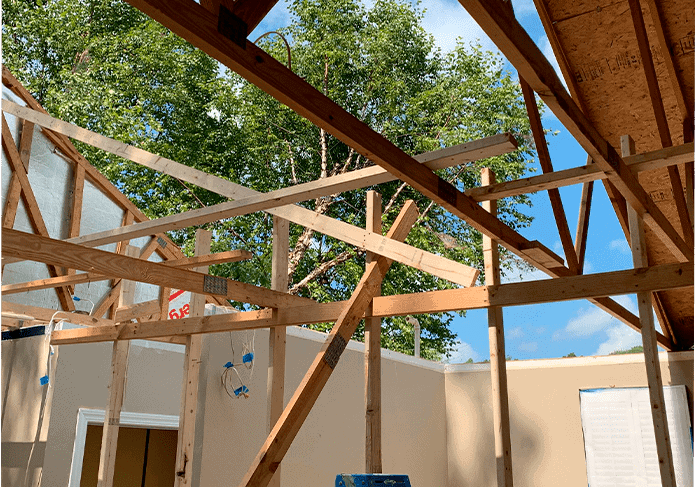 Framed house structure against blue sky